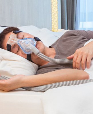 Man sleeping peacefully with CPAP and oral appliance.