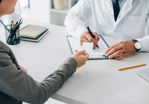 Person handing their doctor a payment card