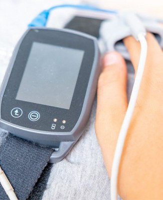 Patient wearing a sleep apnea testing device on their finger.