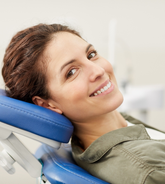 Smiling woman leaning back in dental chair
