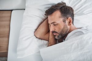 Middle-aged man sleeping peacefully on his side 